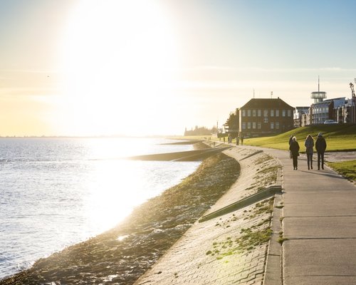 Local citizens walking along the green coastal malecon route during a calm afternoon