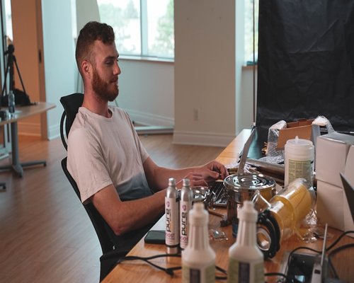 A relaxed professional sitting properly using laptop on a standardized clean tabletop setup